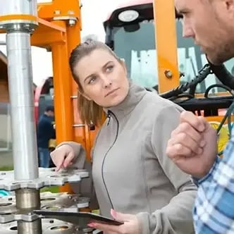 Two service specialists examining an industrial equipment component